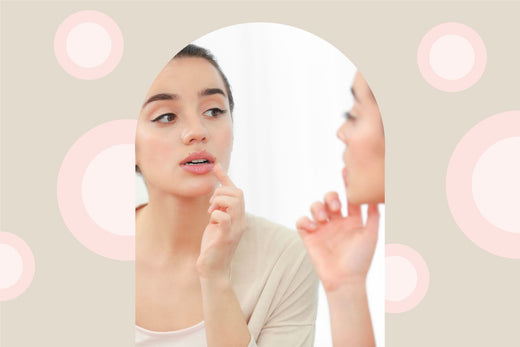 Woman looking in the mirror and touching her lips.