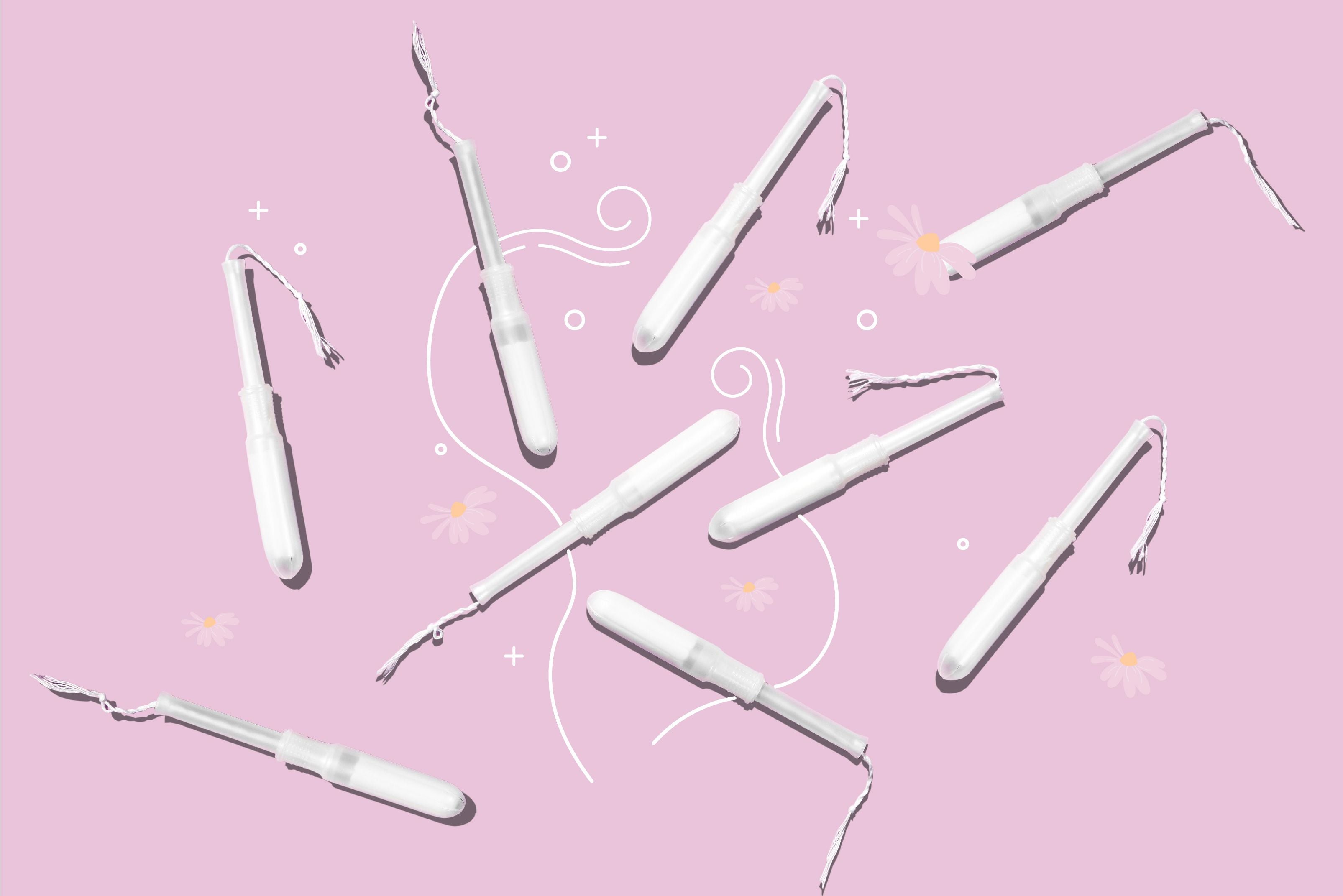 White tampons laying on a pink surface.