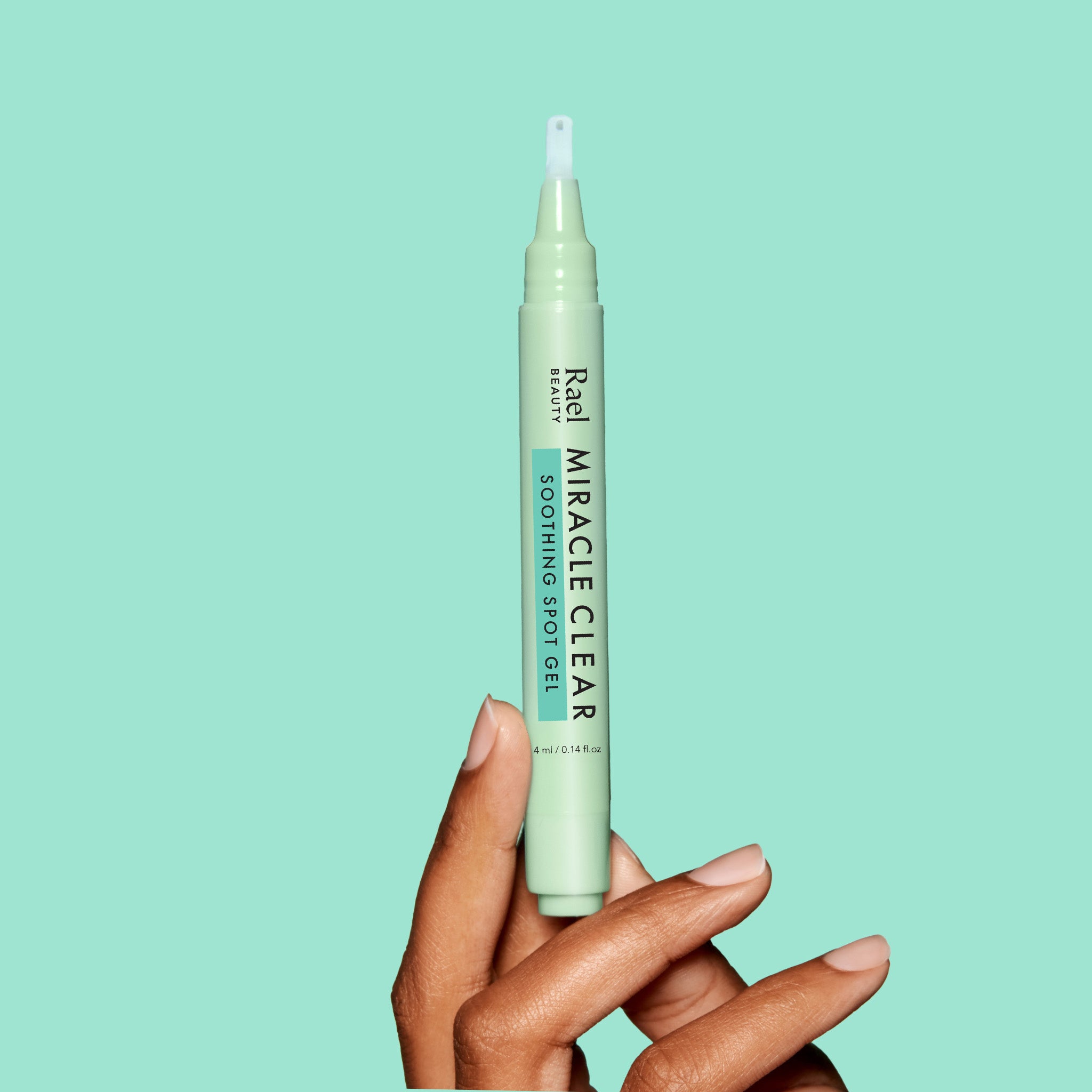 Hand holding a green bottle of 'Miracle Clear' spot gel against a light blue background